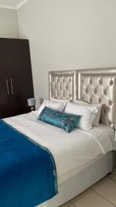 东伦敦Ikhwezi guest house的一张带银色床头板和白色枕头的大床
