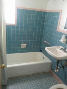 迈阿密海滩考林斯街道旅馆的浴室配有白色浴缸和水槽