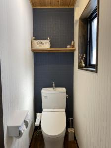 白马村黄色小屋旅馆的浴室配有白色卫生间和盥洗盆。