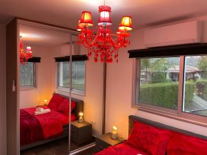 Ayios MamasSOFROS VALLEY HILLS CHALET的一间卧室配有红色的床和镜子