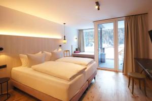 圣安东阿尔贝格Hotel die Arlbergerin ADULTS FRIENDLY 4 STAR的酒店客房设有一张大床和一个阳台。