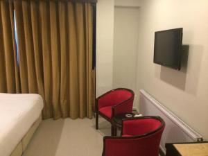 穆里Shangrila Hotels and Resort的酒店客房设有2把红色椅子和电视
