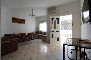 哈曼苏斯Nice Holiday Apartment Hammam Sousse的带沙发和门的客厅