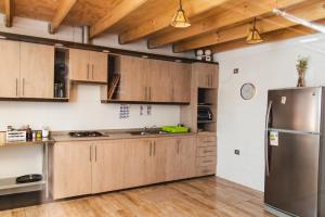 圣佩德罗·德·阿塔卡马Hostal Tulvak Atacama的厨房配有木制橱柜和不锈钢冰箱。