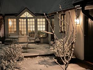 VikenElins Lycka i Viken的雪中门廊上用树遮蔽的