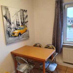 维尔塞伦NiceRooms Aachen的一间设有桌子的用餐室和墙上的黄色汽车