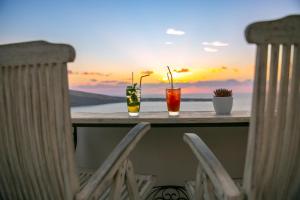 伊亚欧亚马雷别墅酒店的一张桌子上的2杯鸡尾酒,享有海景