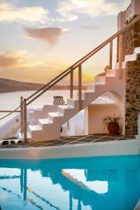 伊亚欧亚马雷别墅酒店的水边的房屋,设有游泳池和楼梯