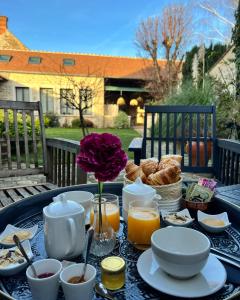 Fleury-en-BièreLa Planque - Chambres avec Jacuzzi的一张桌子,早餐包括咖啡和羊角面包