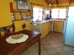 San IsidroCatamarca Hospedaje Star的一间带木桌的厨房和一间带黄色墙壁的厨房