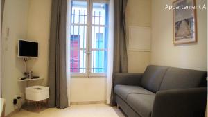 阿尔勒Holiday in Arles: Appartement de l'Amphithéâtre的带沙发和窗户的客厅