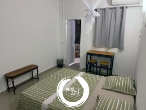 皮特尔角城RETE ZEN GUESTHOUSE的一间卧室配有一张床、一张桌子和一个窗户。