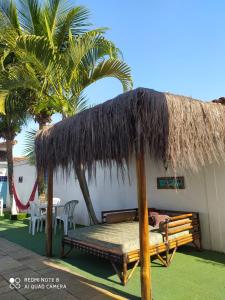 伊塔尼亚恩Hostel Praia Centro Itanhaém的小屋,带床和草屋顶
