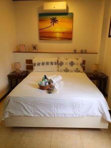 长滩岛绿色庭院酒店的卧室配有白色的床和一篮毛巾