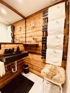 玛利亚采尔Wilderer Suiten Mariazell的浴室配有木墙、水槽和毛巾