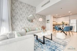 迪拜Alluring 1BR at The Pulse Blvd C3 Dubai South by Deluxe Holiday Homes的客厅配有沙发和桌子