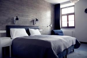 卢布林格罗兹卡街20号酒店的一间卧室配有一张大床和一张蓝色椅子