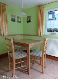 卡劳特格瑞斯赫Michel's Ferienwohnung的厨房里配有一张木桌和两把椅子