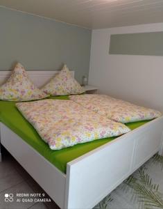 卡劳特格瑞斯赫Michel's Ferienwohnung的卧室配有一张带白色框架和枕头的床。