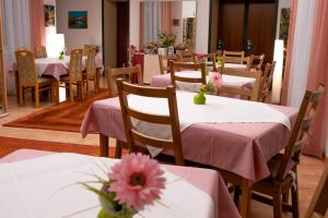 维也纳玛利亚希尔夫膳食公寓酒店的餐厅设有粉红色的桌子和椅子,并种有鲜花