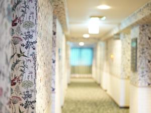 高松Hotel AreaOne Takamatsu City的医院里带花卉壁纸的走廊