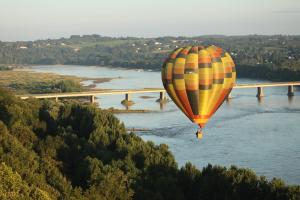 ChamptoceauxGîte Ohlavache!的热气球在河上飞行,有桥