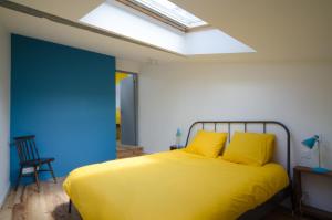 ChamptoceauxGîte Ohlavache!的一间卧室配有一张带黄色床单和天窗的床。