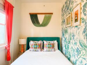 基韦斯特Marreros Guest Mansion - Adult Only的一间卧室配有一张带绿色床头板和枕头的床。