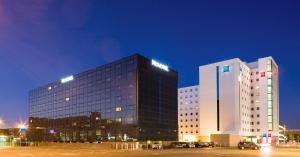 比肯希尔宜必思伯明翰国际机场 - NEC酒店的两个高楼,晚上在停车场