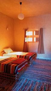 锡瓦Aghurmi Siwa Ecolodge & Salt Cave的酒店客房设有两张床和窗户。