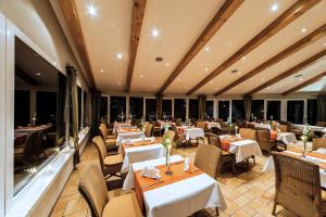 柯莱恩内美洛黑德霍夫海景酒店的餐厅设有白色的桌椅和窗户。