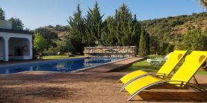 圣布拉什迪阿尔波特尔Quinta da Cortiça的游泳池旁的黄色椅子