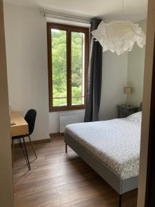 卡普维尔L'AUBERGE DE LA GOUTILLE的一间卧室配有一张床、一张书桌和一个窗户。