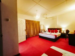 锡吉里亚Pavona Lake的一间卧室配有一张床,铺有红色地毯