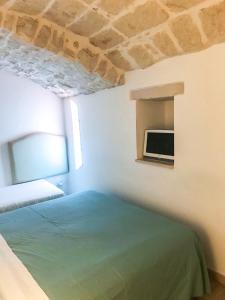 莫尔费塔Mediterranea Deluxe House的卧室配有一张床,墙上配有电视。