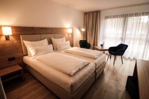 加尔米施-帕滕基兴里赛尔斯酒店的酒店客房设有一张大床和一张书桌。