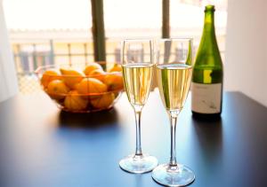 马略卡岛帕尔马L´Aguila Suites - Turismo de Interior的桌子上放两杯香槟和一碗橙子