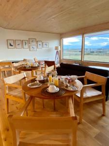 纳塔列斯港Line Hotel Patagonia的一间带两张桌子和一张沙发的用餐室