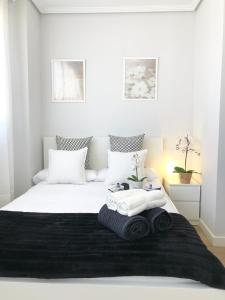 乌迪亚莱斯堡Apto Vistas Mar y Monte Céntrico Garaje Incluido的卧室配有白色床和毛巾
