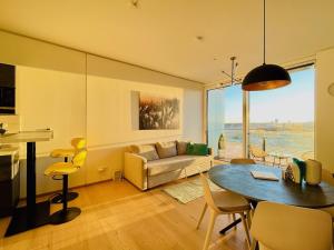 维也纳TrIIIple Level 20 - Sonnenwohnen Apartment mit Parkplatz und fantastischem Ausblick的客厅配有桌子和沙发
