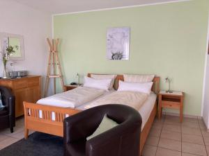 WattenheimLandhaus-Apartments的一间卧室配有一张大床、椅子和椅子
