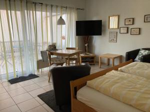 WattenheimLandhaus-Apartments的客厅配有一张床和一张桌子及椅子