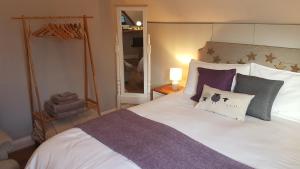 克里克豪厄尔Post Office Row Apartment and garden的卧室配有一张带紫色枕头的大型白色床。