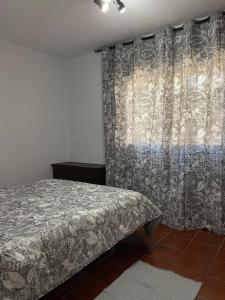 阿德拉Casa al sol的一间卧室配有床和带窗帘的窗户