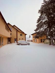 阿列谢尼Casa Raluca的停在雪地覆盖的停车场的汽车