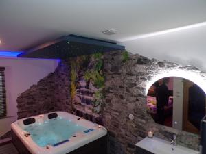 Jarville-la-MalgrangeLoveroom 54的一间石墙内带浴缸的浴室