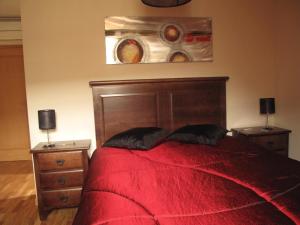 塞亚Cantinho da Estrela的一间卧室配有红色的床和2个床头柜