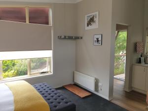 金德拜恩Lakeside Studio的一间卧室配有一张床、一把椅子和窗户。
