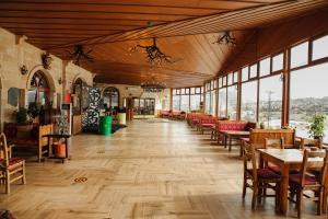 内夫谢希尔Emin Koçak Hotel Kapadokya的用餐室设有桌椅和窗户。