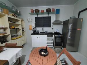 巴纳内拉斯Tiny Home Garden Bananeiras的带冰箱和桌子的厨房